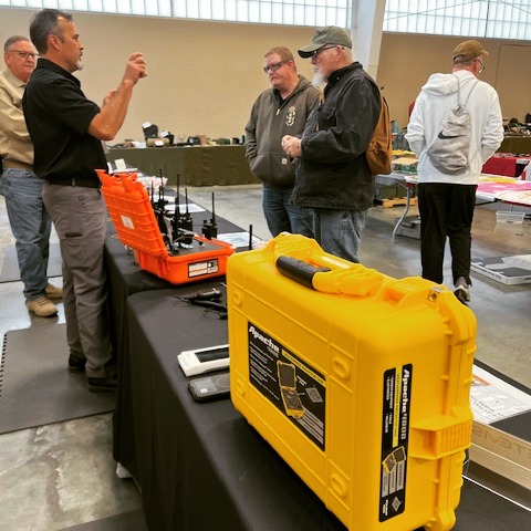 SkyCom PTT team demonstrating radios to attendees at a trade show